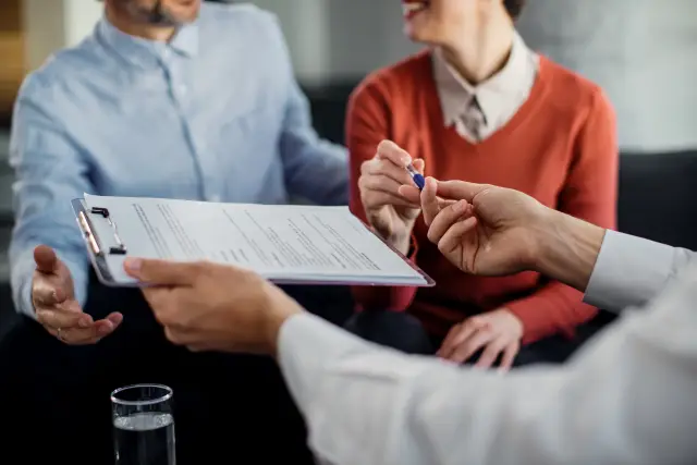 Closeup of couple signing a contract