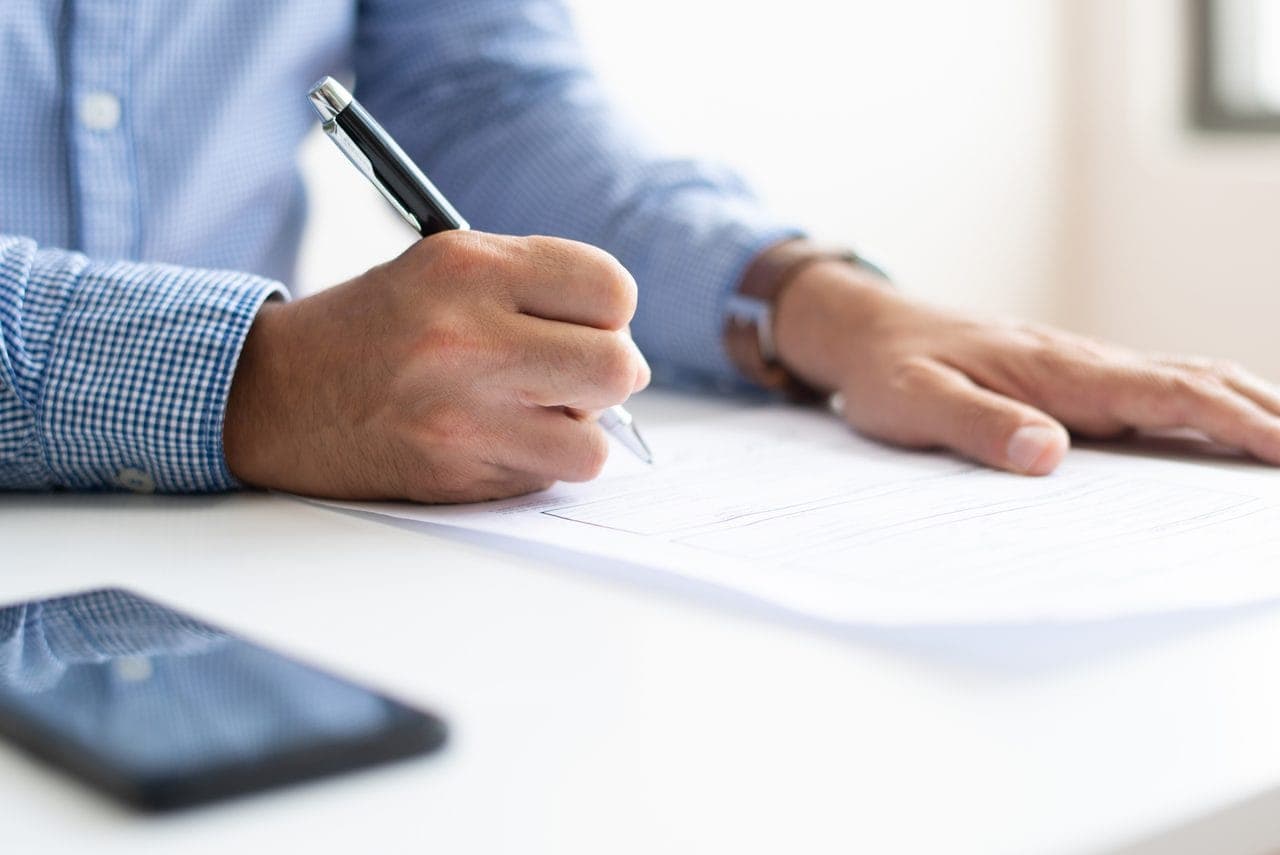 Closeup of male candidate filling in an application form